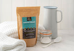 Ecoliving Natural Earth Bleach Percarbonate of Soda pictured next to glass jar and metal jug
