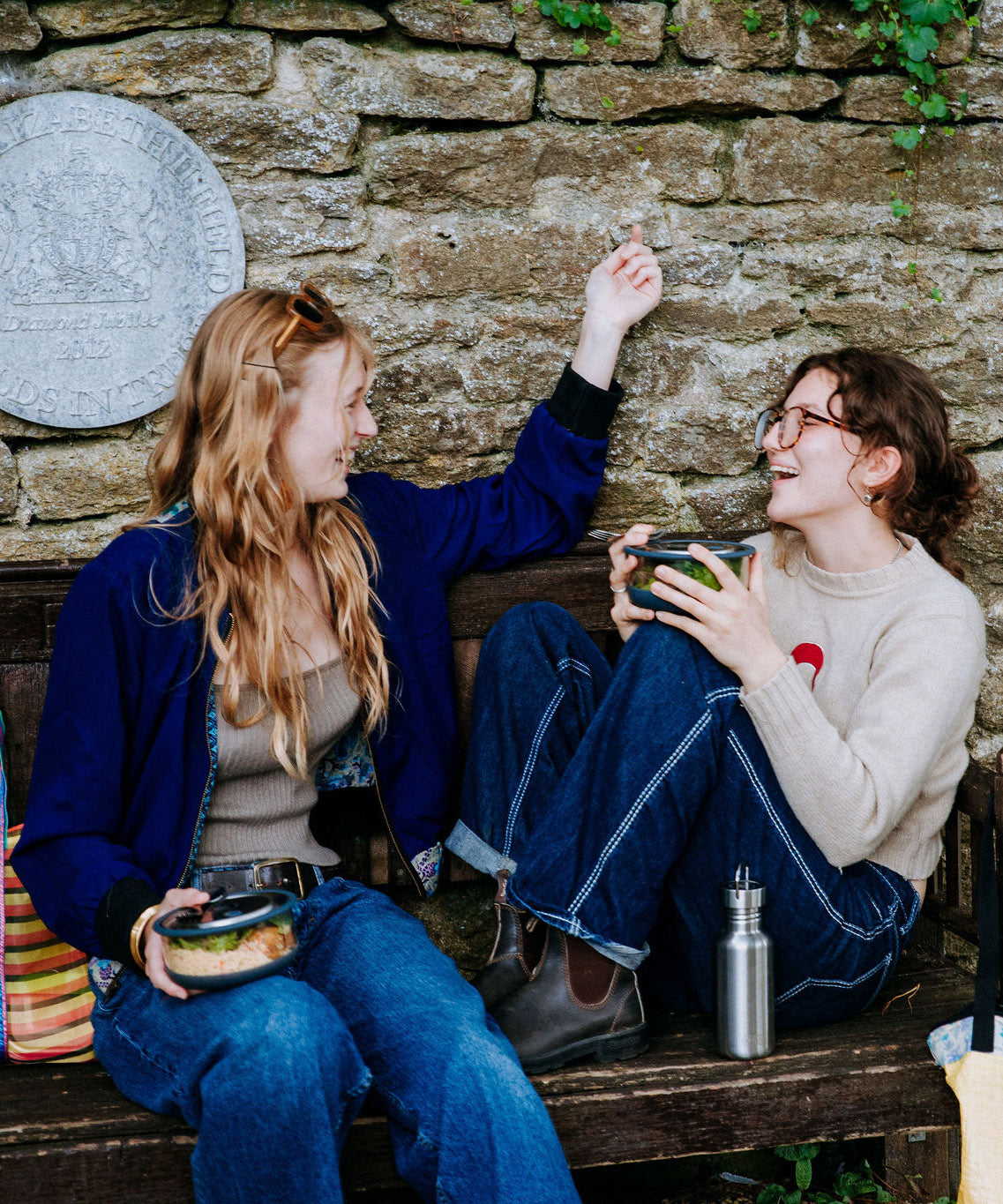 2 women sitting on a bench and eating from their Elephant box bowls. The medium and large bowls are available at Babipur. Features a removable lid and a silicone base.