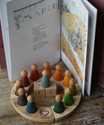 The Around The Year children's hardback book by Elsa Beskow shown open on the pages for March and placed behind a Grapat Welsh perpetual calendar with the date arch the 1st shown. 