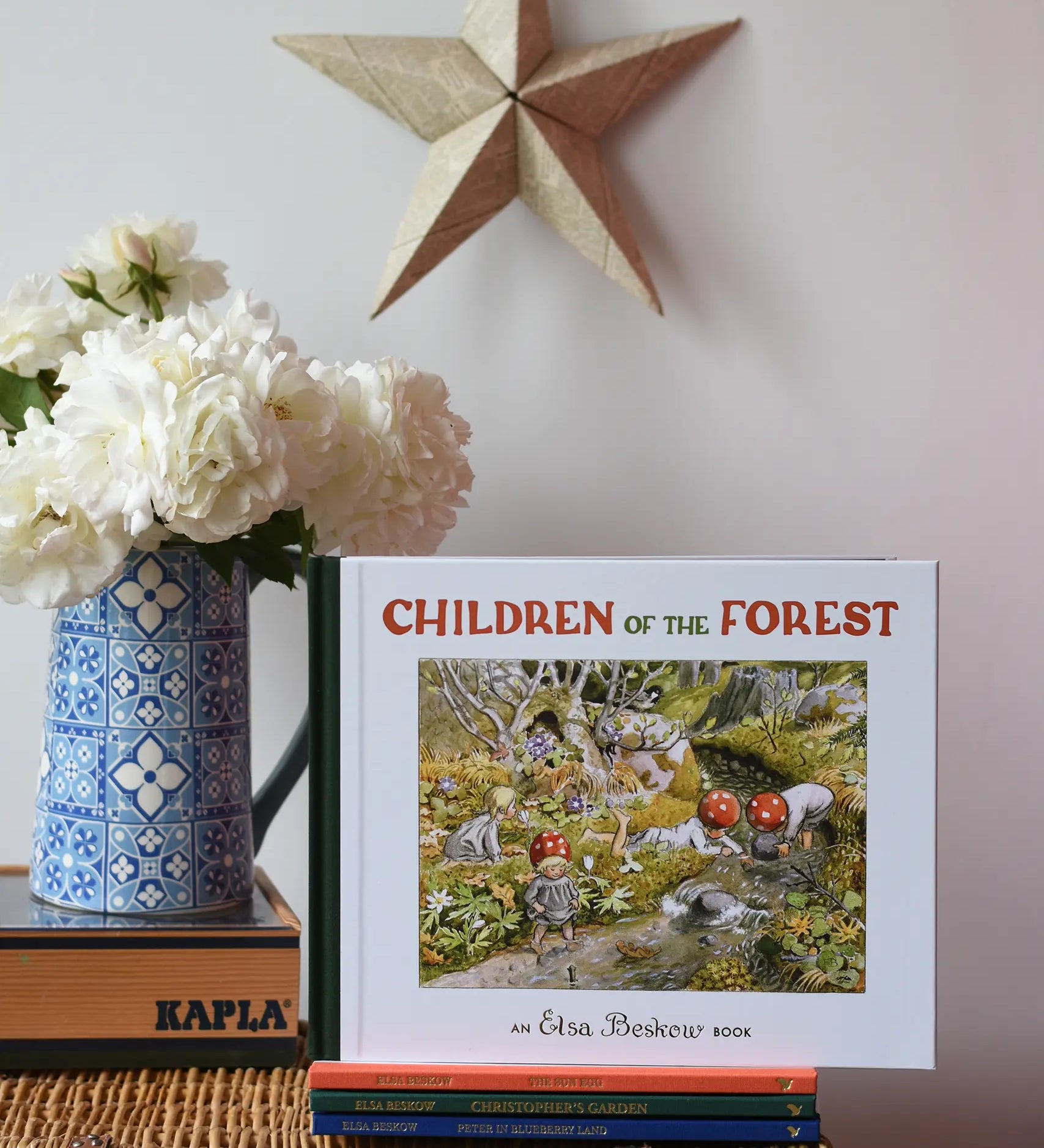 Children of the forest children's hardback book by Elsa Beskow placed on a wicker hamper on a stack of other Elss Beskow books.