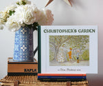 Christopher's garden children's hardback book by Elsa Beskow placed on a wicker hamper on a stack of other Elss Beskow books.