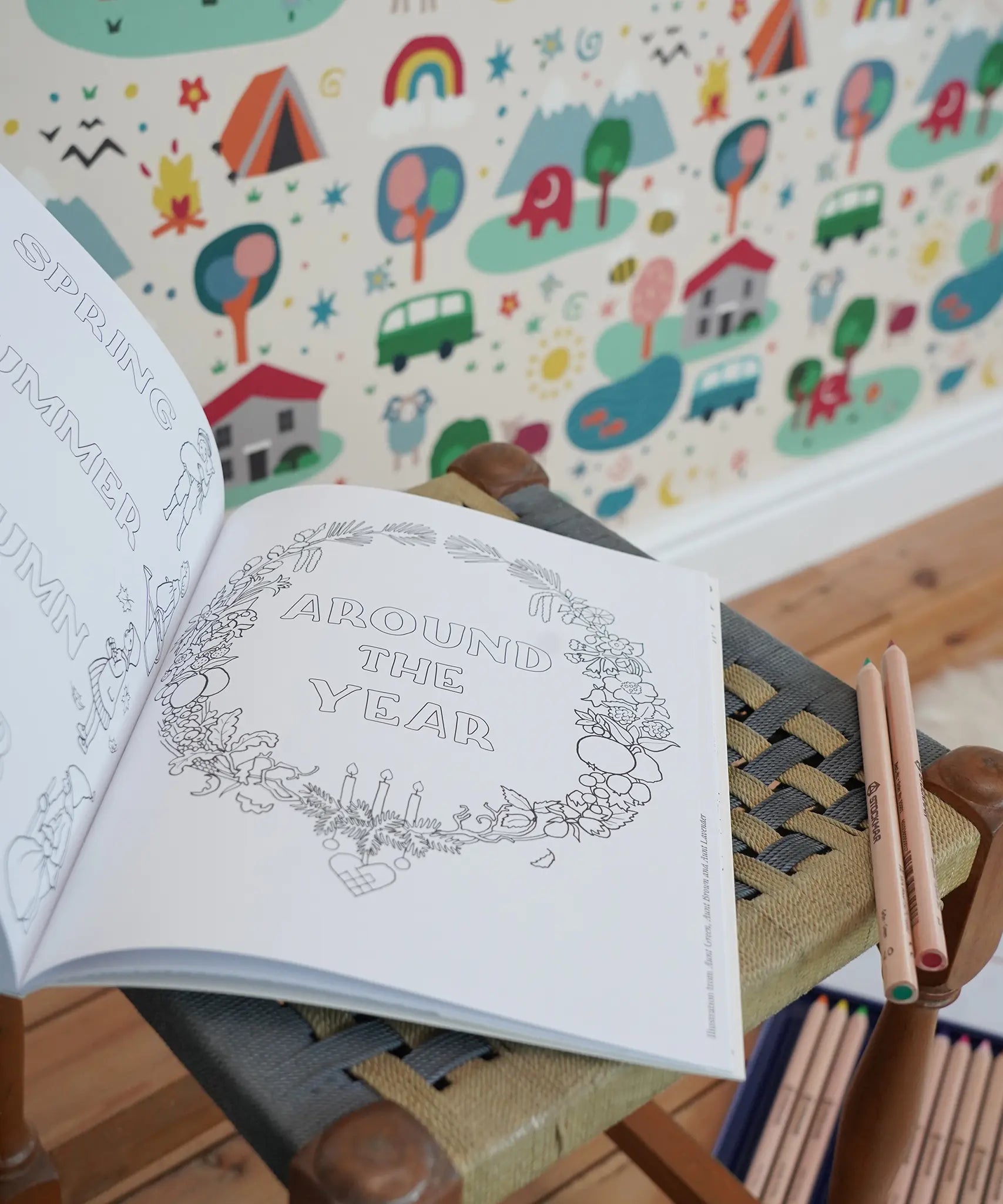 Inside page from the The World of Elsa Beskow: A Vintage Colouring Book placed on a stool in the Babipur playroom. Black and white line art coloring page. 