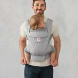 Ergobaby omni deluxe baby carrier  SoftTouch cotton in pearl grey. Baby worn in carrier facing the parent.