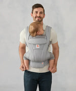 Ergobaby omni deluxe baby carrier  SoftTouch cotton in pearl grey. Baby worn in carrier facing the parent.