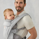 Ergobaby omni deluxe baby carrier  SoftTouch cotton in pearl grey. Baby worn in carrier facing the parent.