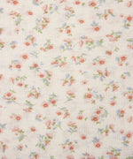 Ergobaby aura sustainably knitted wrap carrier showing a close up of the repeated bloom design on light pink fabric.