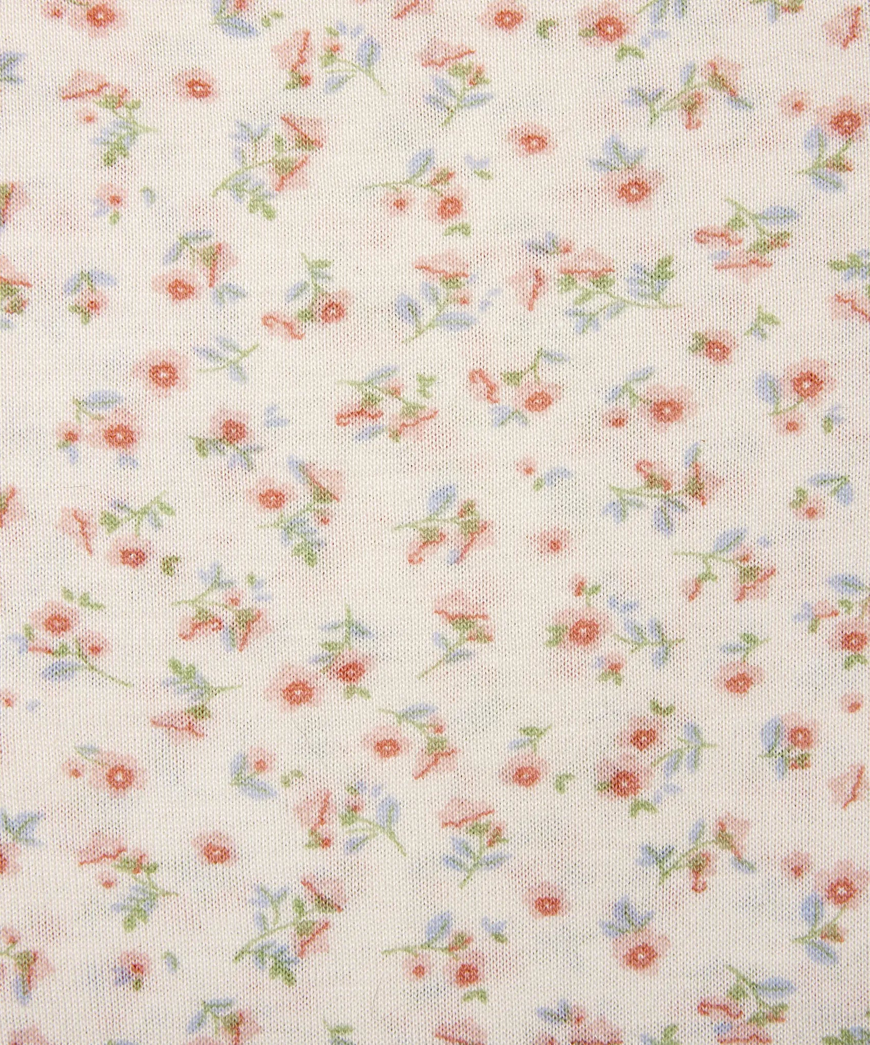 Ergobaby aura sustainably knitted wrap carrier showing a close up of the repeated bloom design on light pink fabric.