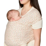 Side of mother carrying a baby in the Ergobaby aura sustainably knitted wrap carrier in dainty blooms in the frontal position