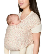 Side of mother carrying a baby in the Ergobaby aura sustainably knitted wrap carrier in dainty blooms in the frontal position