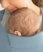 Close up of baby's head facing inwards in the Ergobaby Embrace Soft Knit Newborn Baby Carrier in Oxford Blue. 