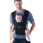 Man wearing a blue top and his baby on his front facing outwards in the Ergobaby Embrace Soft Knit Newborn Baby Carrier in Pure Black. Front view white background.