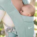 Close up of a baby facing inwards in the Ergobaby Embrace Soft Knit Newborn Baby Carrier in Jade. Side view garden background.