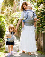  and both are wearing matching carriers. The child is wearing the Kids Doll Carrier