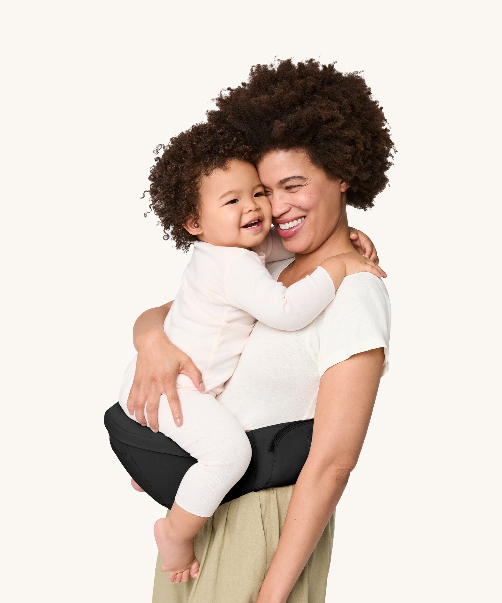 A woman carrying her baby on the Ergobaby Lift Hip Seat carrier, in Onyx Black. 