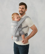 Ergobaby omni deluxe baby carrier  SoftTouch cotton in pearl grey. Baby worn in carrier facing the parent.