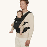 A man wearing the Ergobaby Omni Deluxe Mesh baby carrier in Onyx Black, with a little baby being carried facing outwards. 