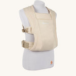 The Ergobaby Soft & Snug knit newborn baby carrier in a soft cream colour, from a side angle view.