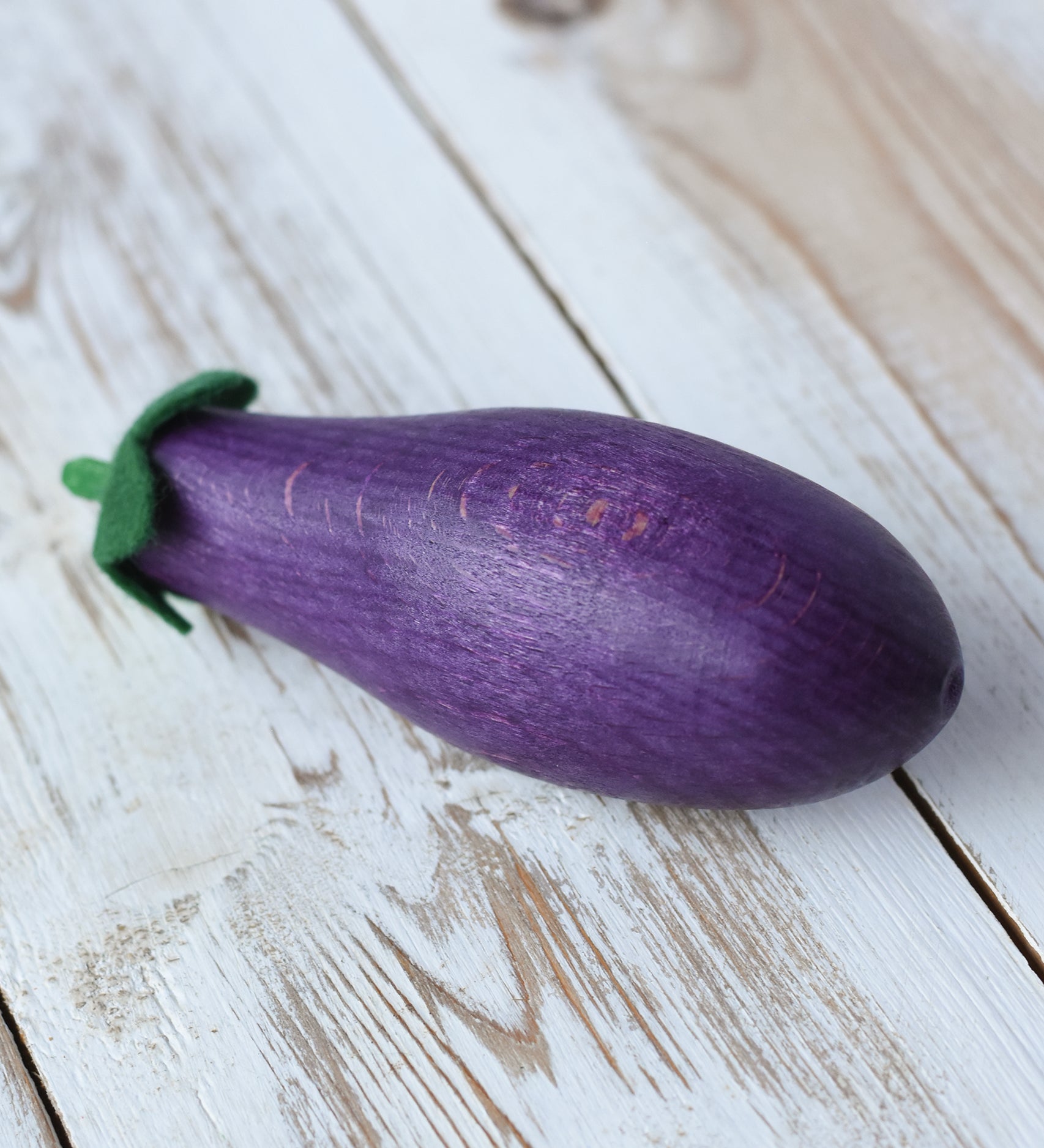 Erzi aubergine eggplant wooden play food placed on a wooden surface. 