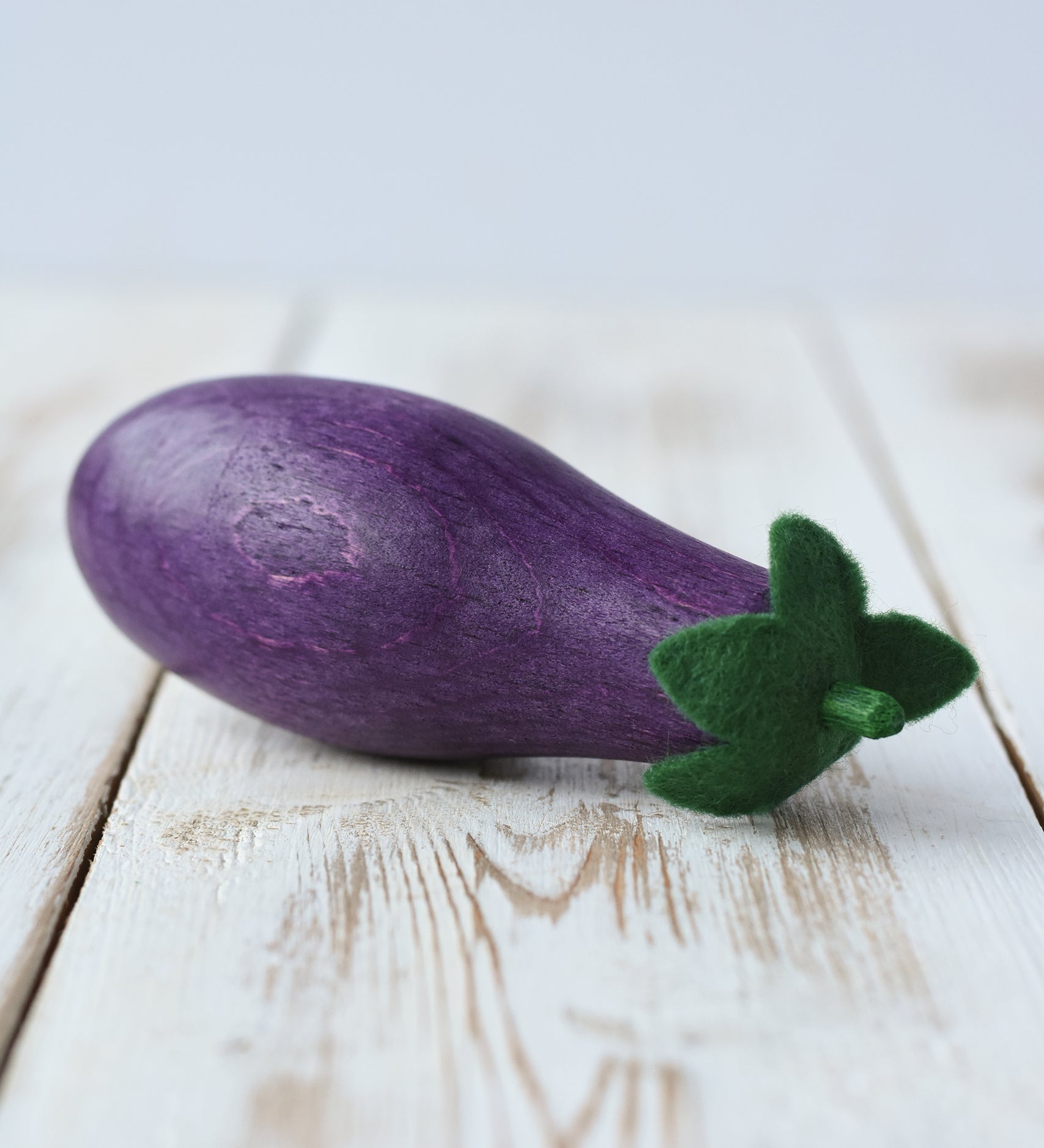 Erzi aubergine eggplant wooden play food placed on a wooden surface. 