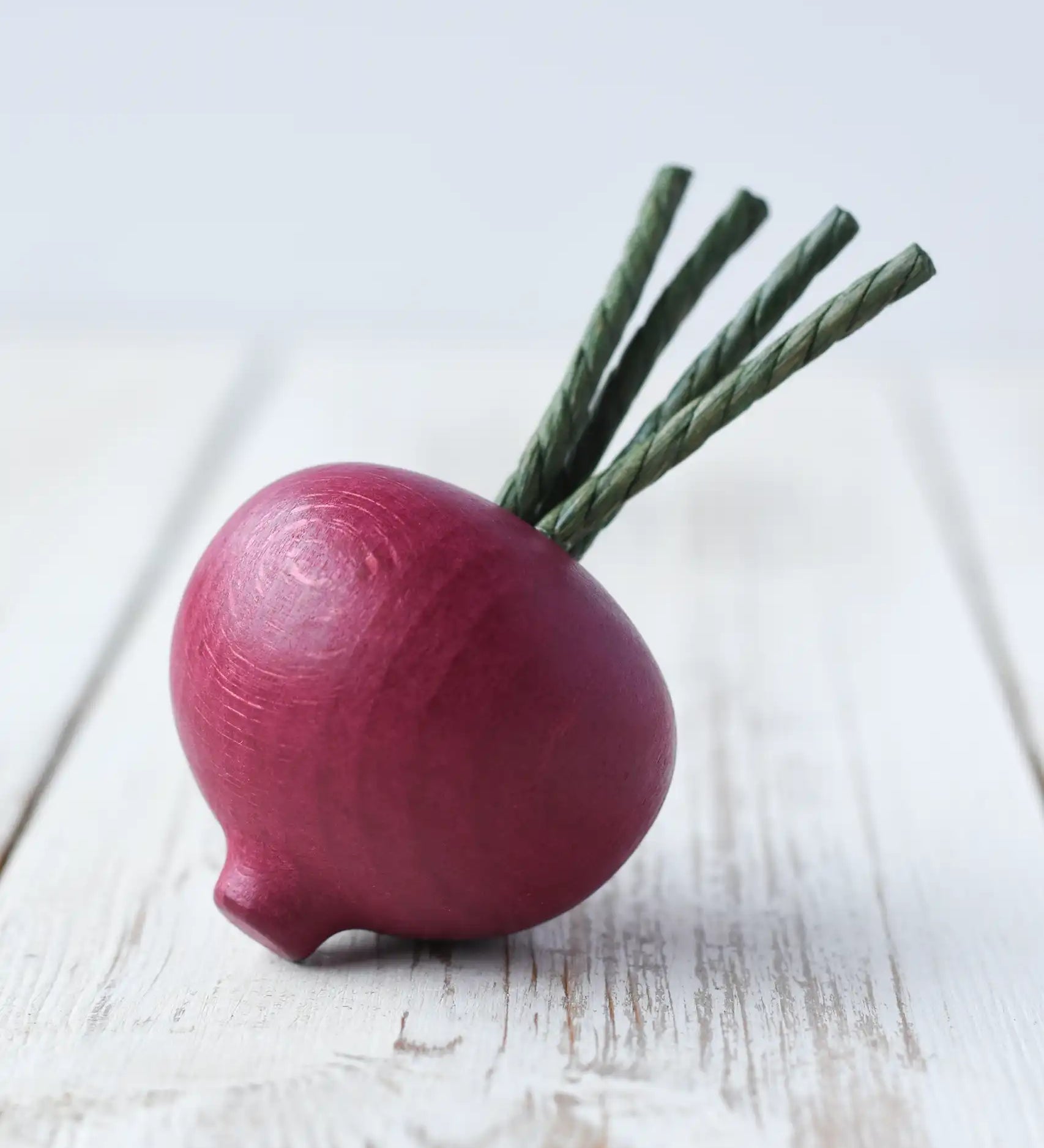 Erzi wooden play food beetroot placed on a wooden surface. 