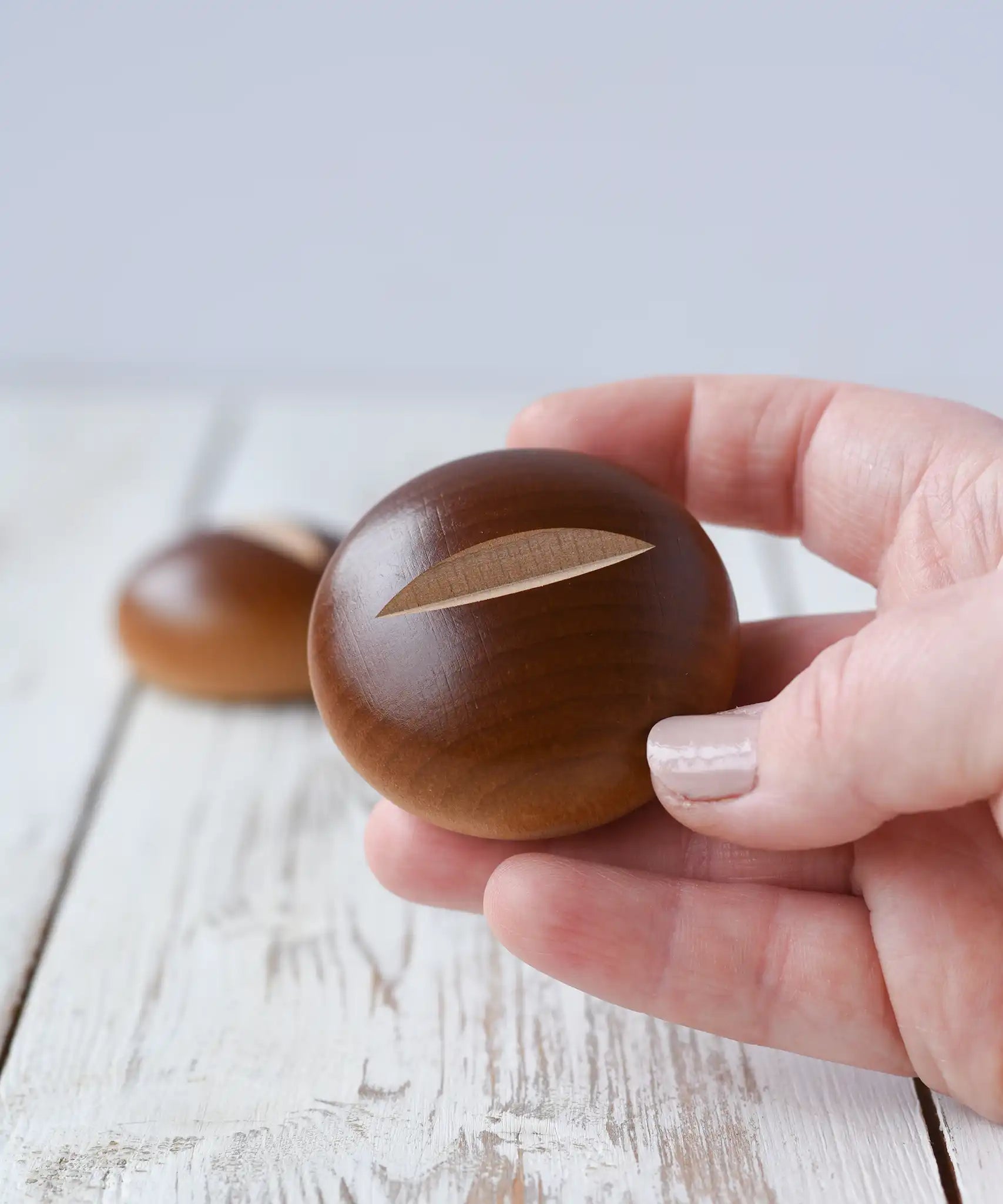 Erzi bread roll wooden play food in an adult's hand. 