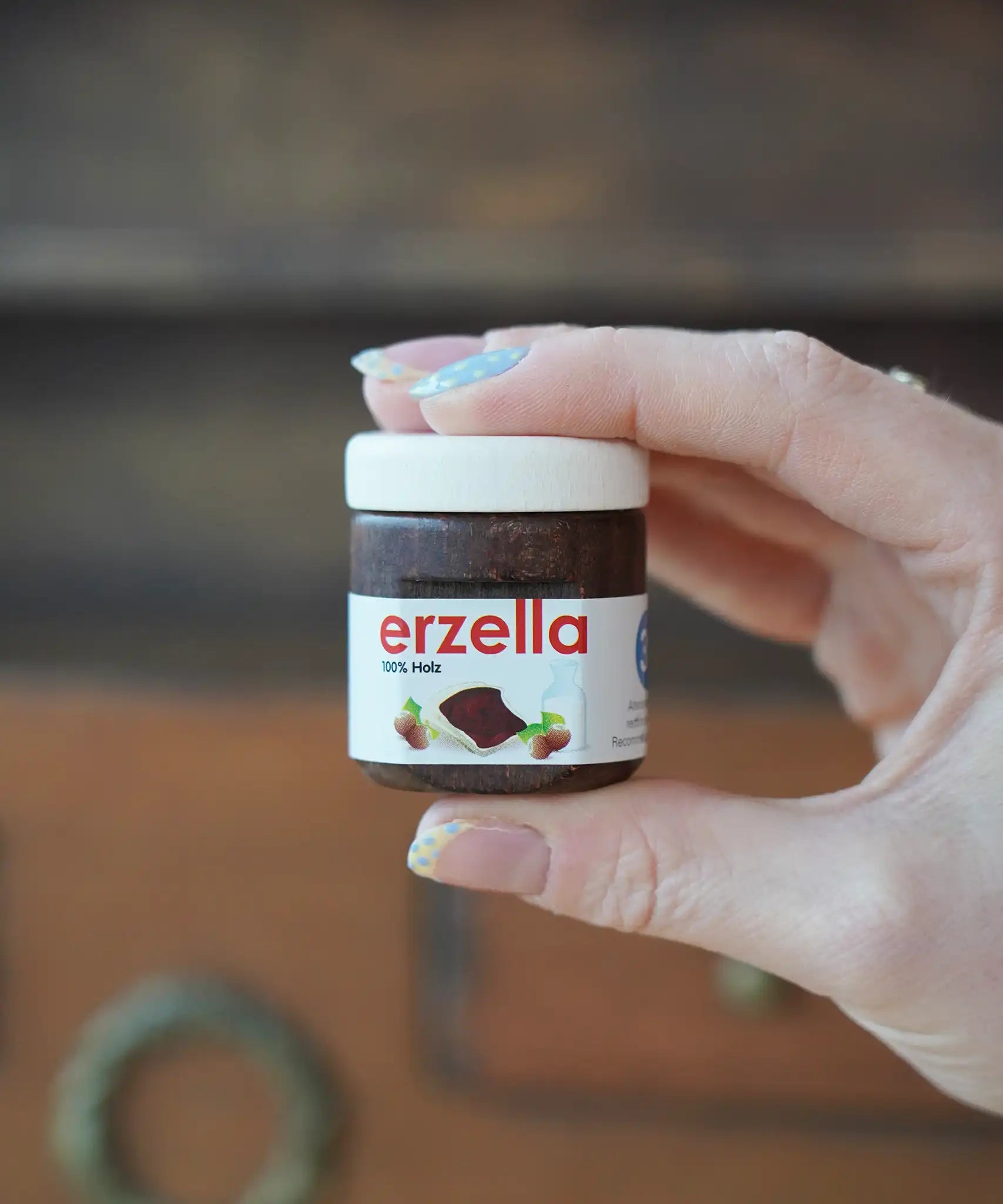 Erzi Erzella chocolate spread wooden play food shown in an adult's hand.
