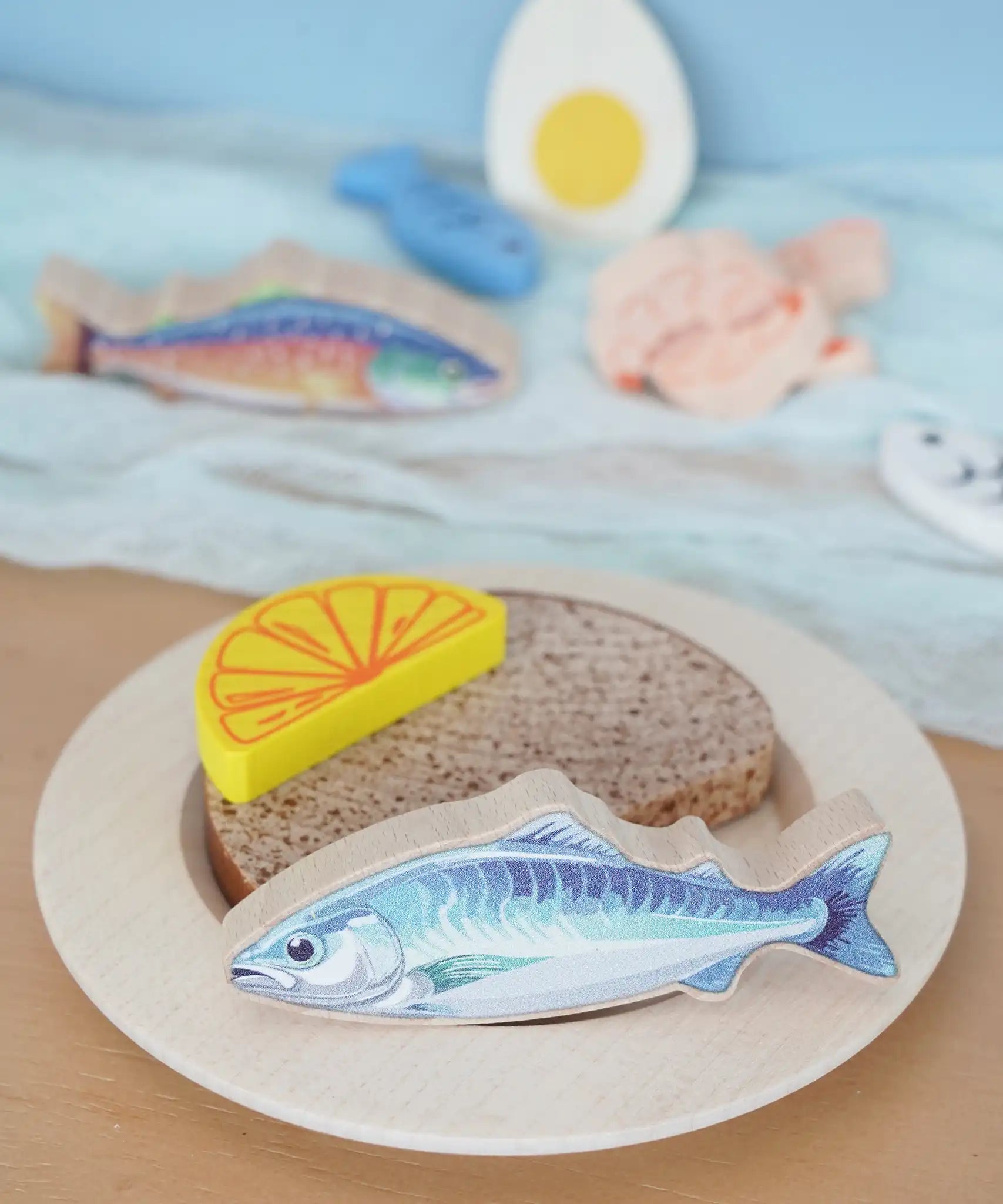 Pieces from the Erzi fish assortment wooden food play set used to create a meal in the  Babipur playroom.