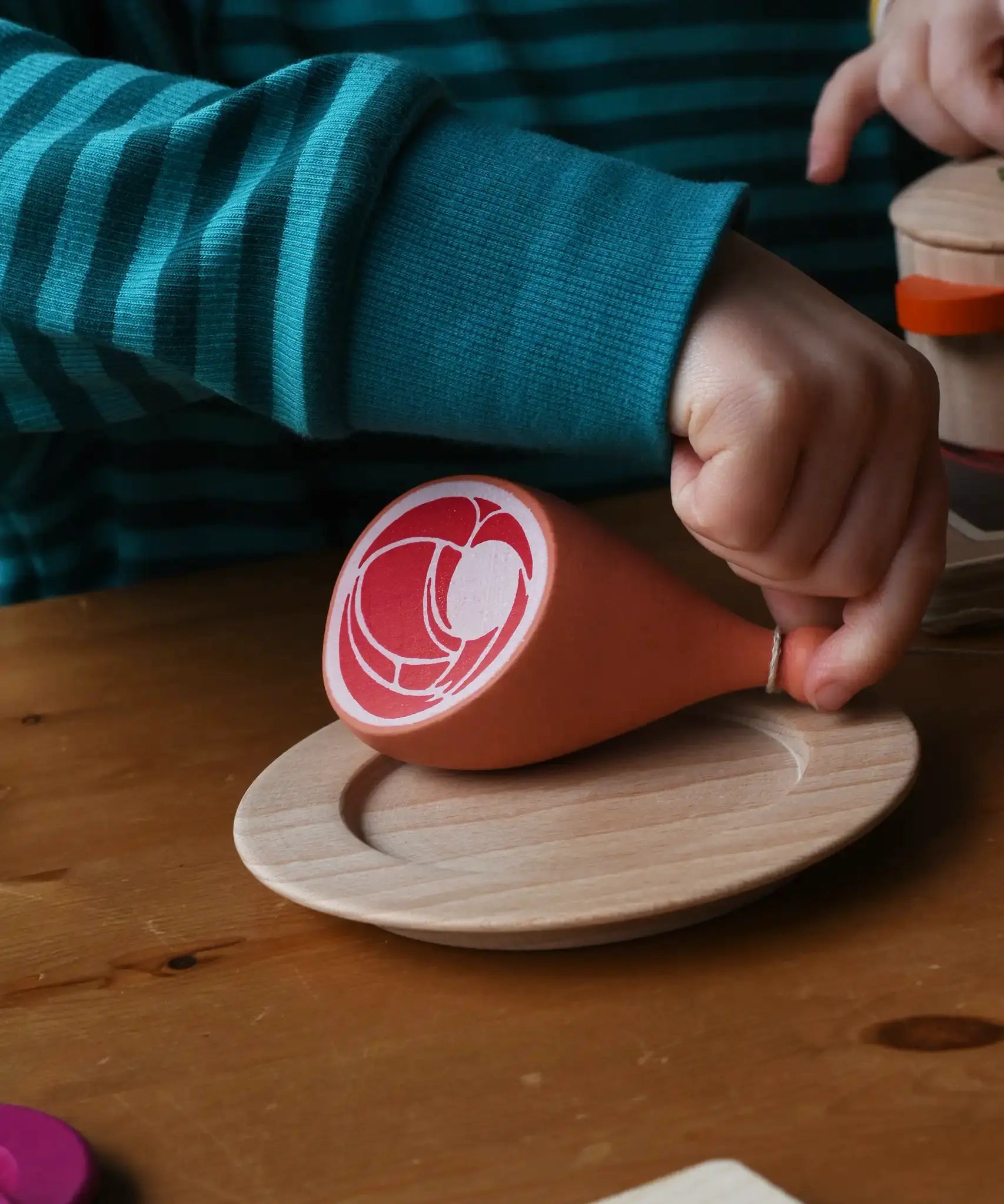 Erzi Gammon joint Wooden Play Food placed on a wooden toy place, child's hand picking up the meat. 
