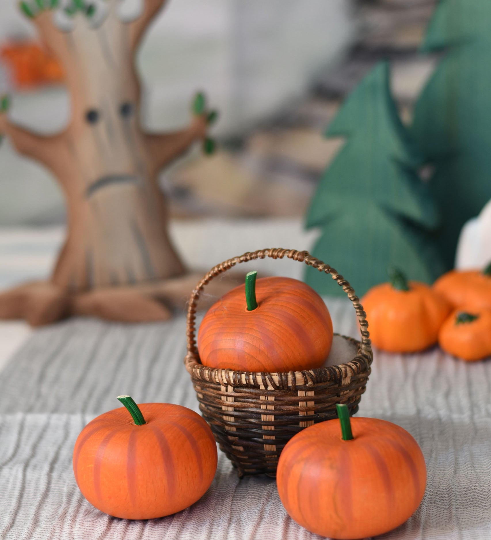 An Erzi pumpkin placed in a Kraul basket with two other Erzi pumpkins placed in front of it. 