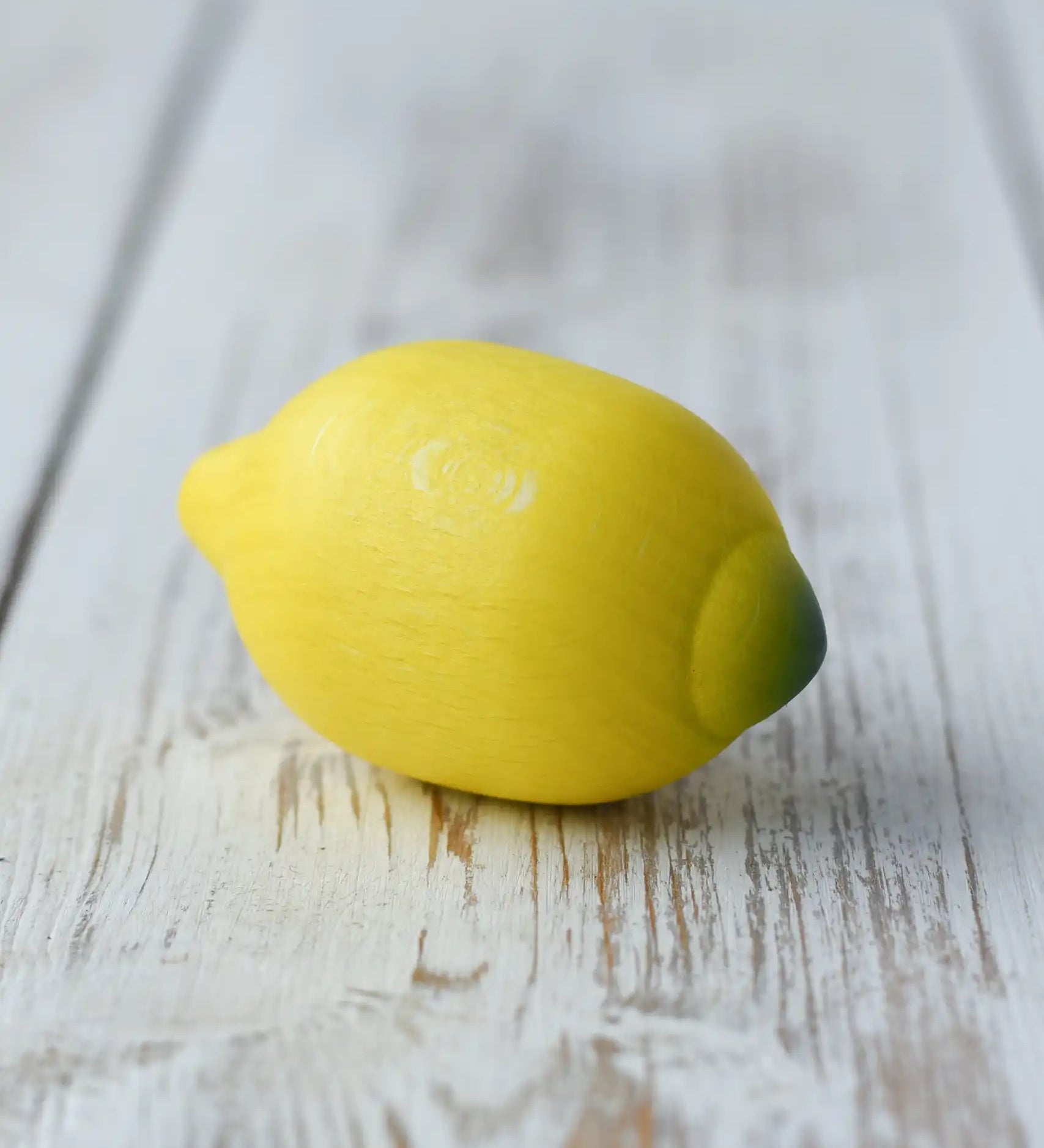 Erzi lemon wooden play food realistic yellow play food placed on a wooden surface.