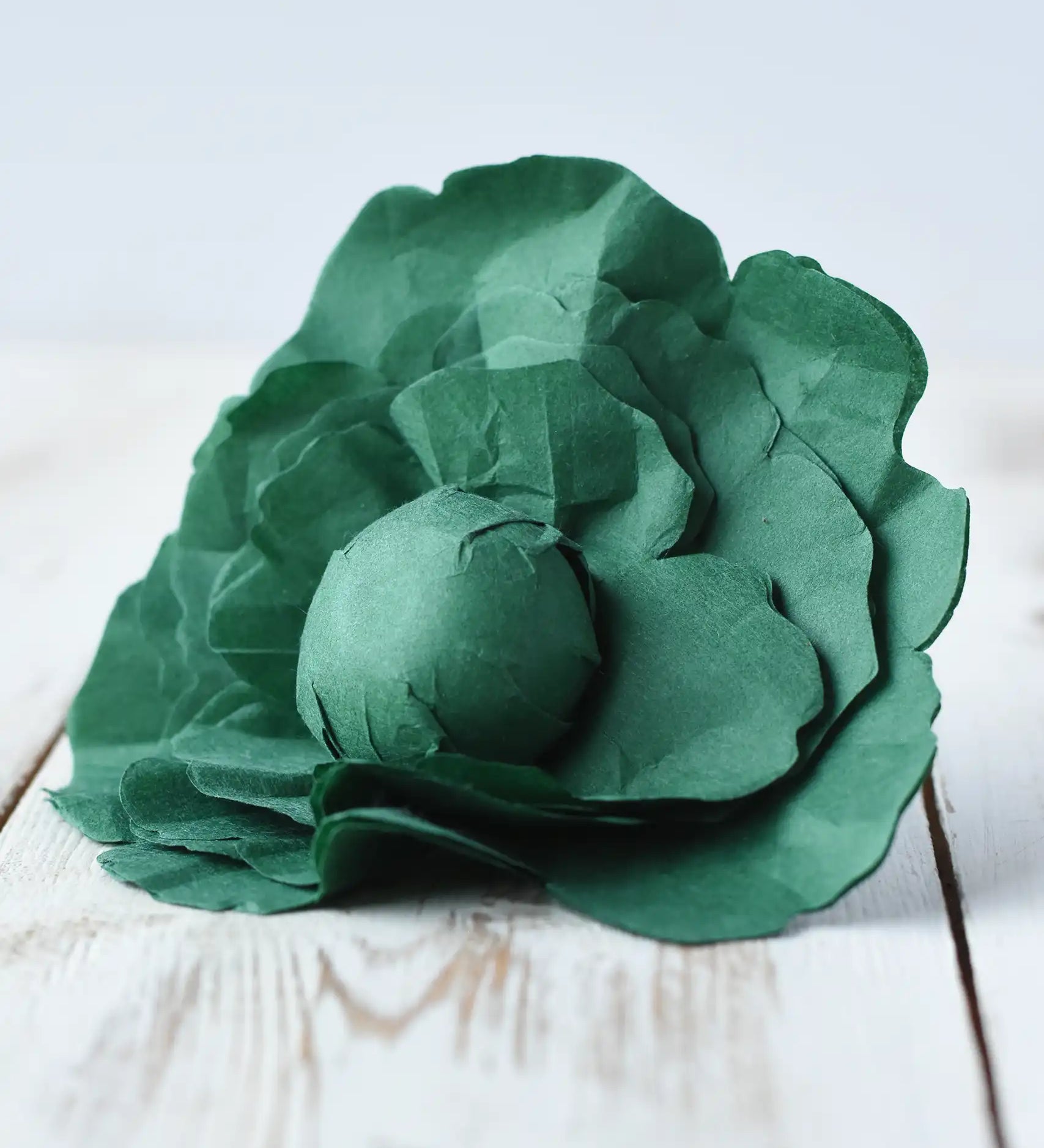 Erzi lettuce paper like fabric play food placed on a wooden surface. 