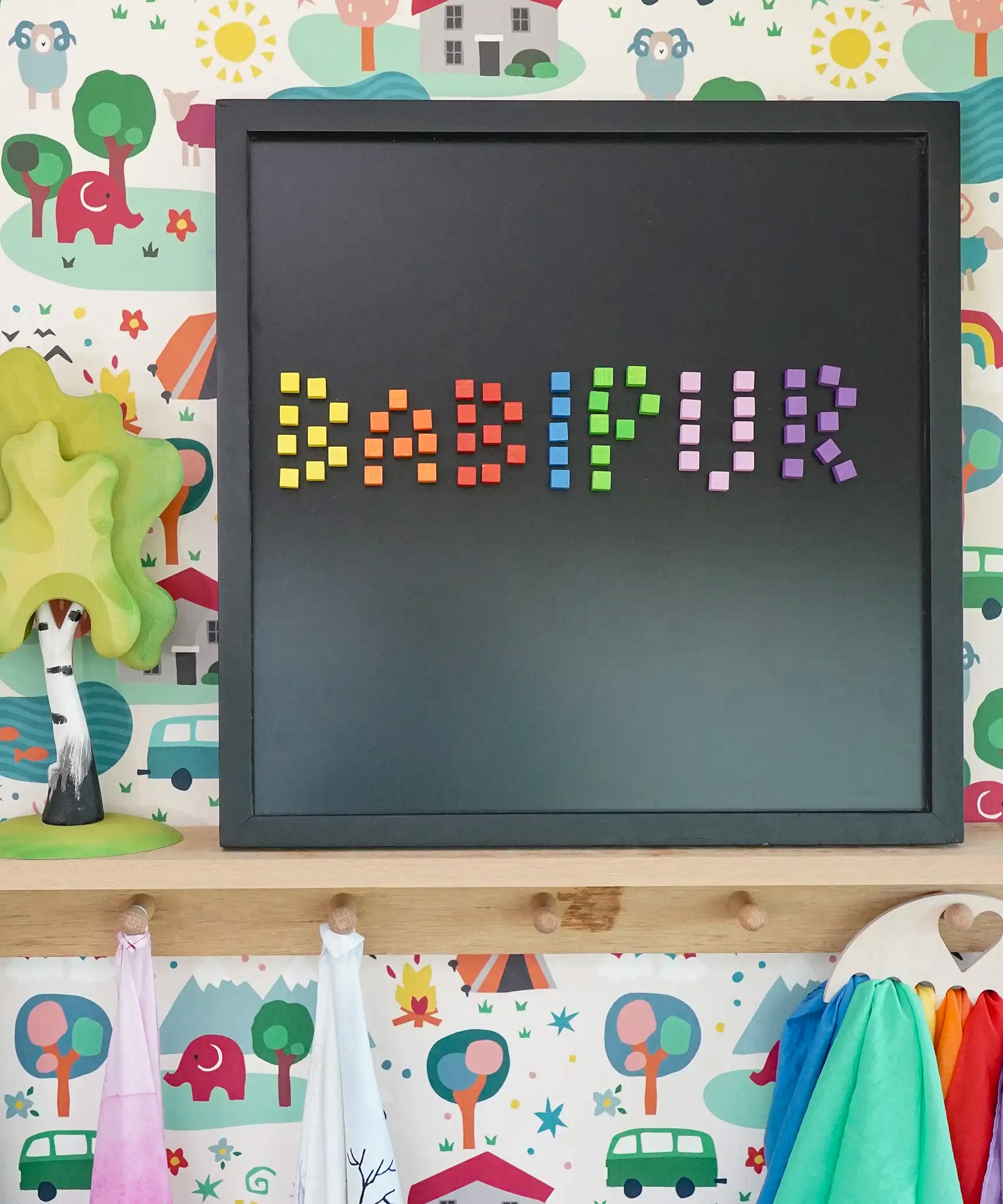 Erzi pixelino magnetic blocks spelling Babipur on a Grimm's black magnetic board
