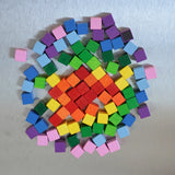 A colorful set of small Erzi wooden magnetic blocks from the pixelino set on a Triclimb Biri board