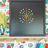 A mandala pattern on a black Grimms magnetic board using Erzi pixelino magnetic blocks 