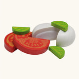 Erzi mozzarella and tomato wooden play food set that comes with two mozzarella piece that join together with velcro, two tomato halves and three basil leave. 