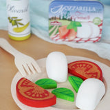Erzi mozzarella and tomato in a metal tin wooden play food set placed on a wooden plate in the Babipur playroom.