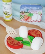 Erzi mozzarella and tomato in a metal tin wooden play food set placed on a wooden plate in the Babipur playroom.