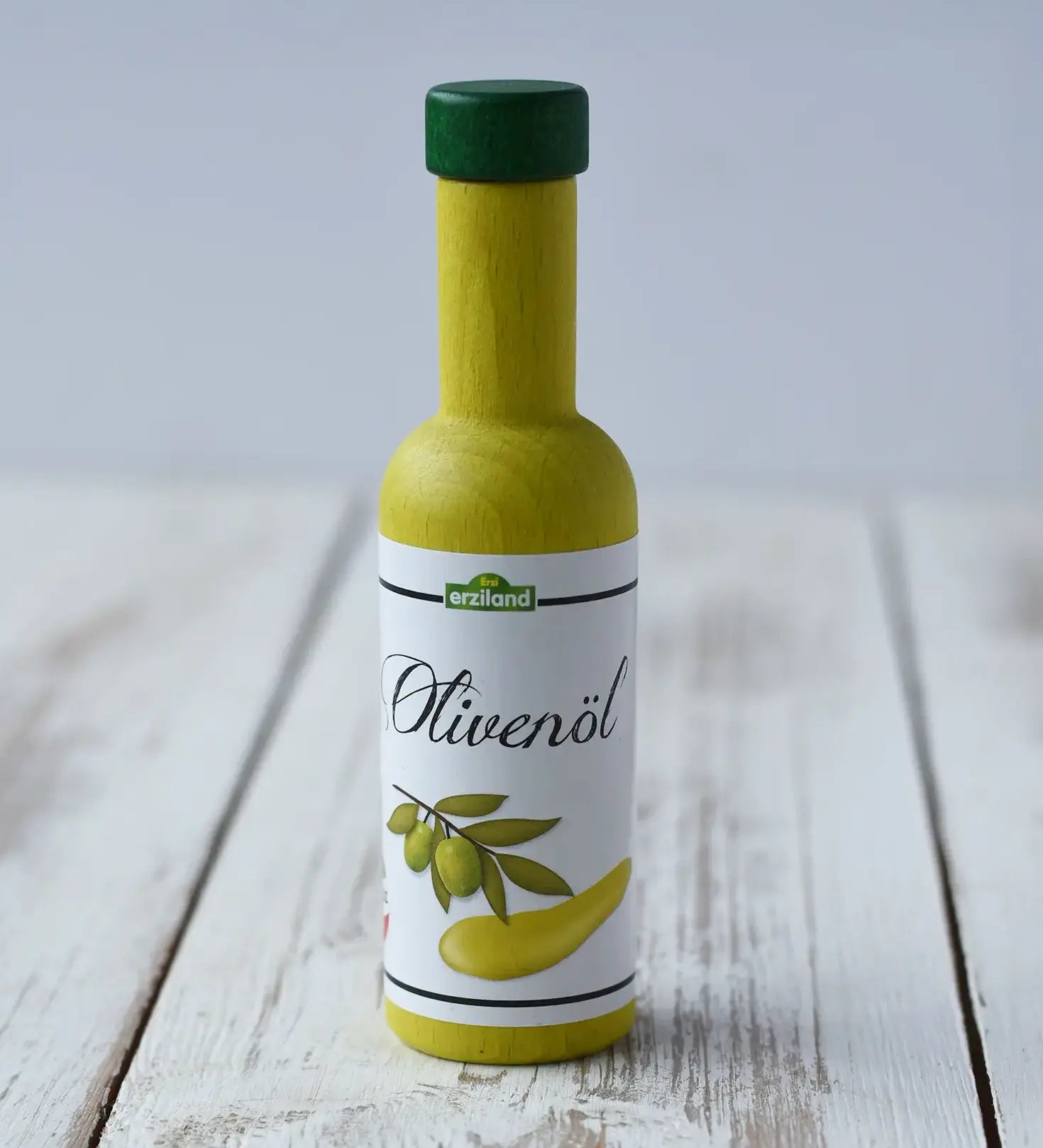 Erzi olive oil bottle wooden play food placed on a wooden counter.