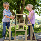 Children playing with the Erzi wooden outdoor building block set. They are stacking the large blocks on top of each other.