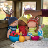 Child's hand reaching for dollies placed inside the Erzi pine wooden outdoor dollhouse play set. 2 sided, 2 level play house for toys. 