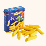 Erzi children's wooden play food penne pasta laid out next to the metal tin they come in.
