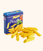 Erzi children's wooden play food penne pasta laid out next to the metal tin they come in.