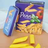 Erzi children's wooden play food penne pasta laid out next to the open metal tin they come in in the Babipur playroom.