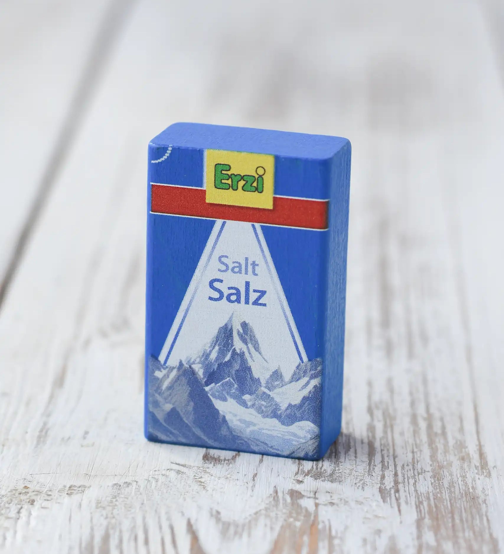 Erzi salt wooden play food packet placed on a wooden surface. Blue packet with erzi branding on the front.