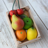 Erzi small wooden toy crate filled with wooden play food fruits placed on a wooden surface. 