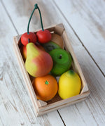Erzi small wooden toy crate filled with wooden play food fruits placed on a wooden surface. 