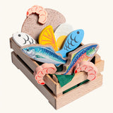 Erzi fish assortment wooden food play set in a wooden crate. Set contains 5 types of fish, 3 shrimps, bread, half and egg and lemon slice.
