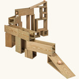Erzi Outdoor Building Blocks with 24 wooden pieces stacked to form a ball run.