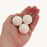 Erzi White Wooden Marbles 30mm Beech Set for Trackboards and Open-Ended Play. The three white marble are shown in an adult's hand for scale. 