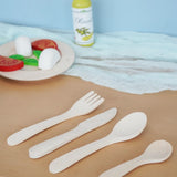 Erzi wooden toy cutlery set placed on a wooden surface in the Babipur playroom with wooden play food in the background.